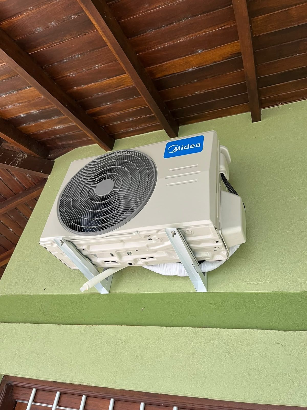 Condensadora Midea instalada nos suportes, com acabamento